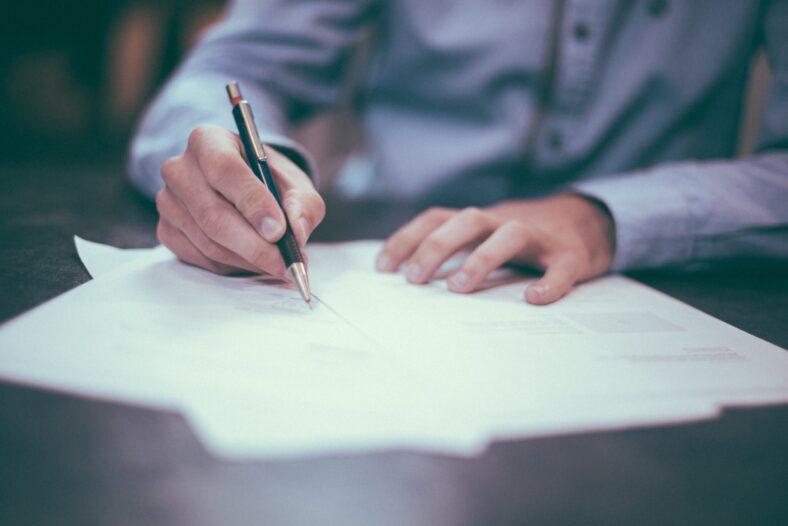 Man holding a pen writing