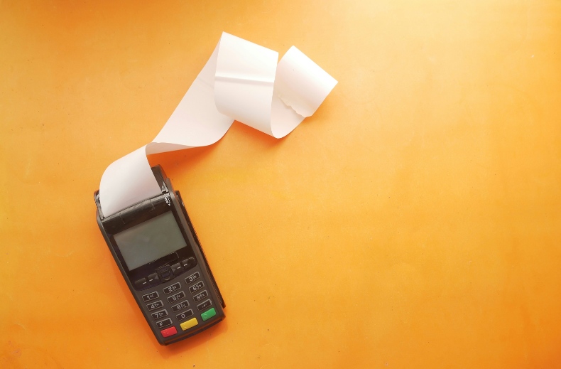 a credit card reader with a long white paper roll