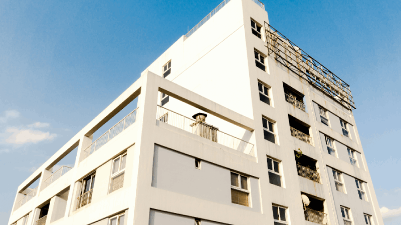 A photo of a white-facaded apartment building